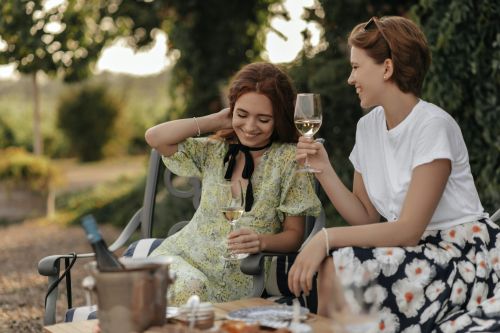 Two female residents at the meridian enjoying a glass of wine in the park