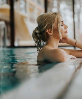 A relaxing spa-like atmosphere at The Meridian featuring a woman enjoying a soak in a sleek bathtub.